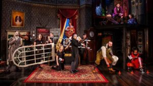 Cast members holding inanimate objects on stage